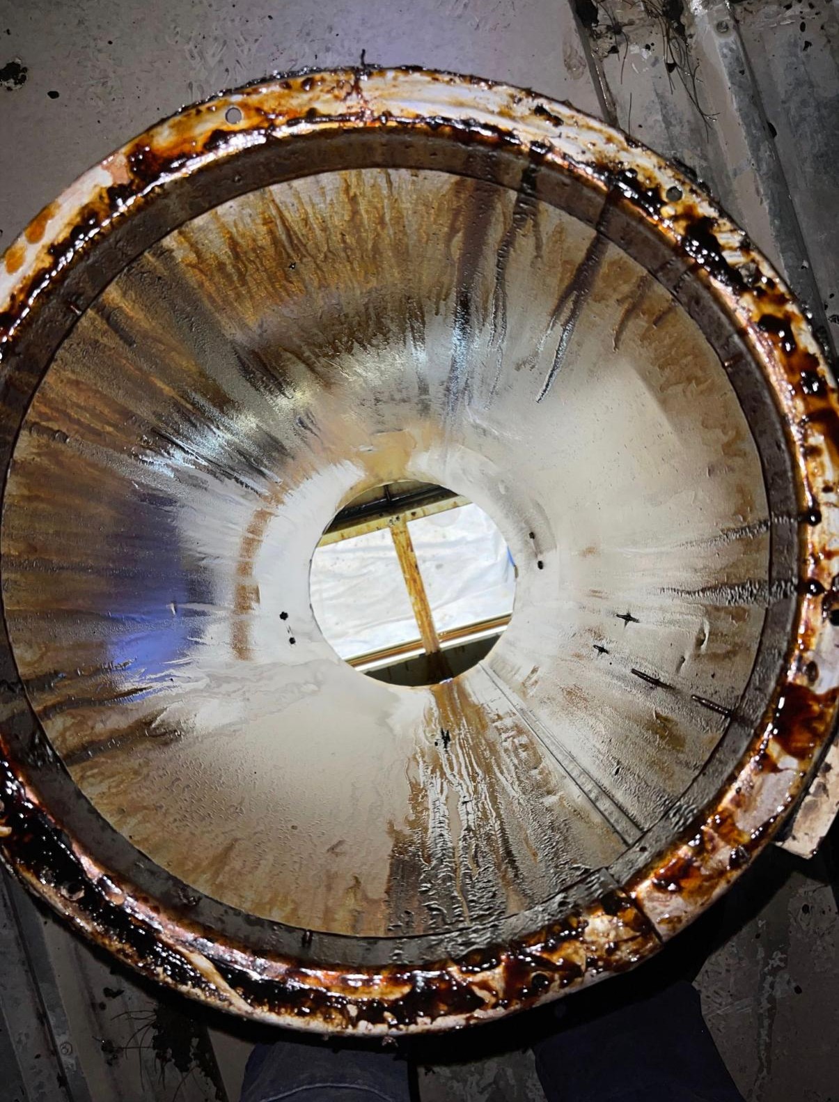 Vertical duct riser viewed from the roof before cleaning, showing grease build-up